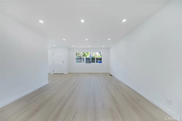 an empty room with a hardwood and ceiling fan