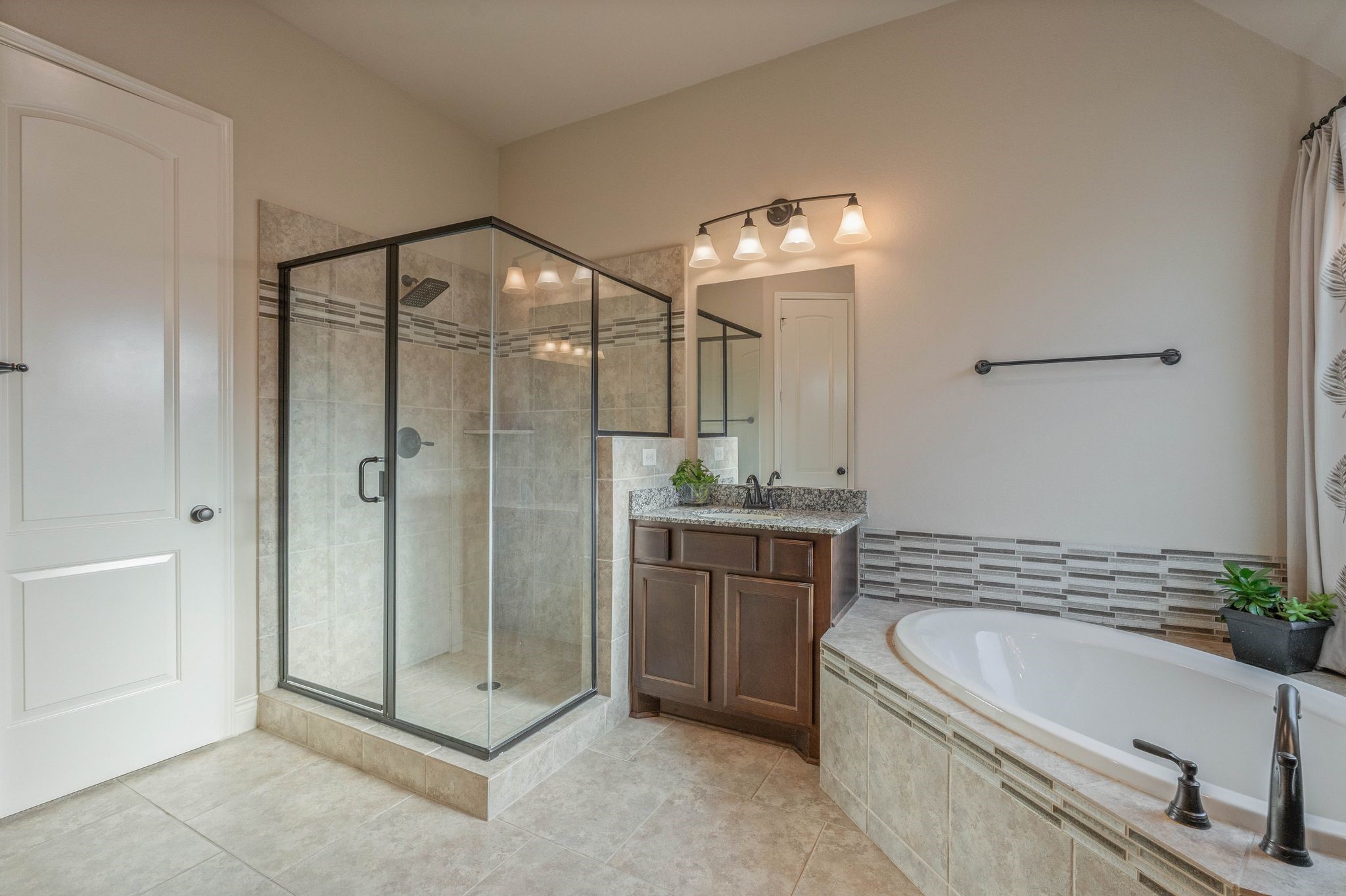 23306 Ridge Spring Drive New Caney, TX 77357 - Photo 28 of 45 a bathroom with a granite countertop tub a sink and a large mirror