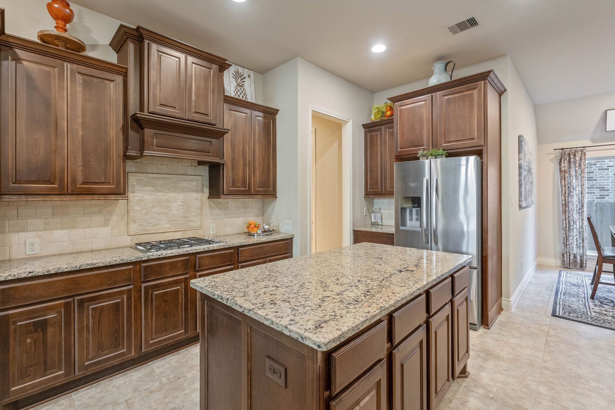 23306 Ridge Spring Drive New Caney, TX 77357 - Photo 9 of 45 a kitchen with stainless steel appliances granite countertop a refrigerator a sink and wooden cabinets