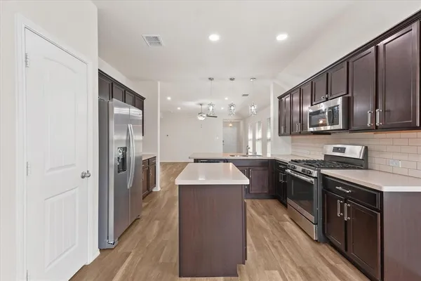 a kitchen with stainless steel appliances granite countertop a sink stove and refrigerator