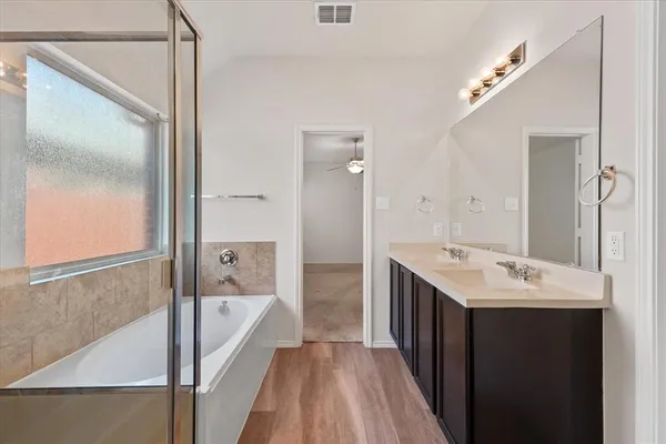 a spacious bathroom with a tub sink and mirror