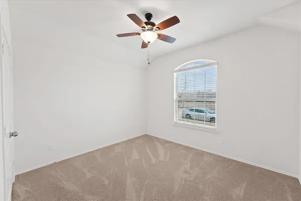 an empty room with a window and a ceiling fan