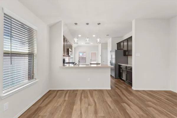 a view of kitchen and hall with wooden floor