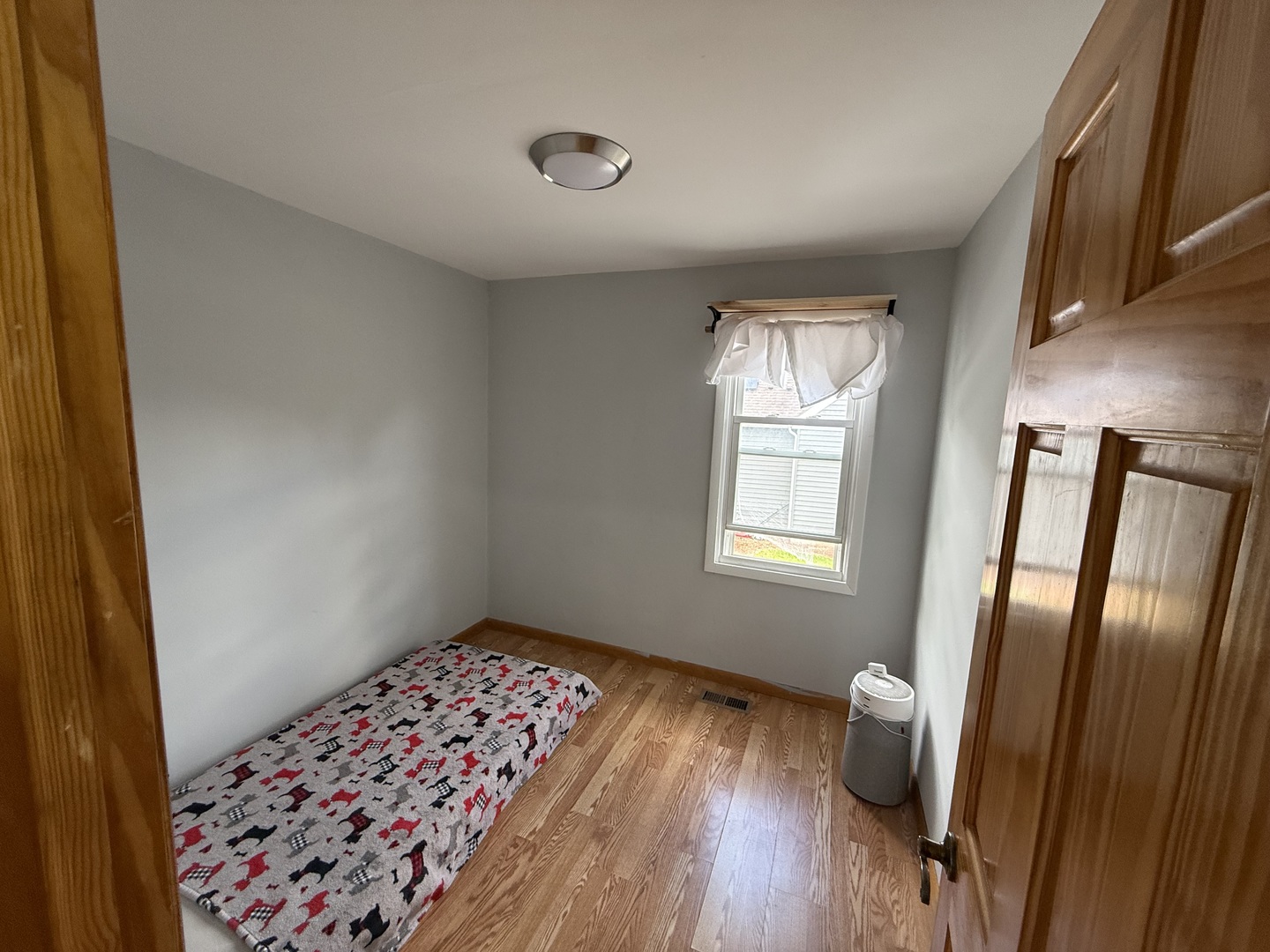 208 West Nippersink Road Round Lake, IL 60073 - Photo 12 of 32 a view of an empty room with wooden floor and a window