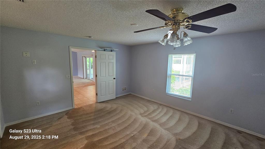 21 Lloleeta Path Palm Coast, FL 32164 - Photo 8 of 17 an empty room with chandelier fan and windows