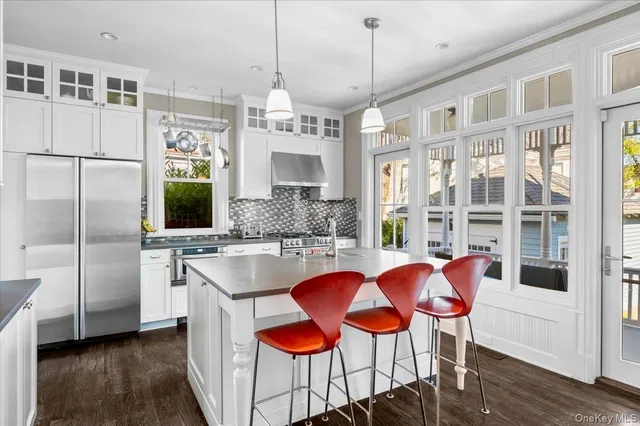a kitchen with stainless steel appliances granite countertop a kitchen island a stove a table and chairs in it