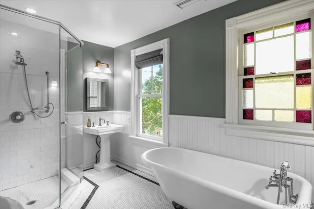 a bathroom with a tub a sink and a window