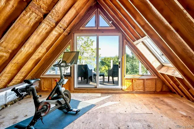 a view of an empty room with wooden floor and windows