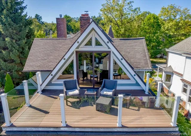 a view of house with wooden stairs and a bench