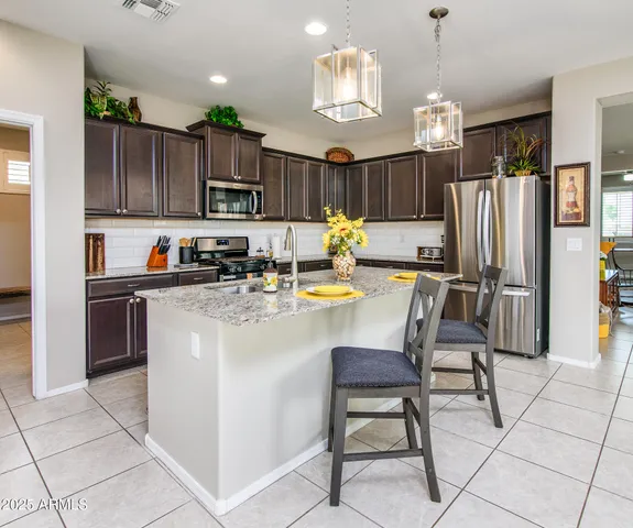 a kitchen with stainless steel appliances granite countertop a stove refrigerator sink and cabinets