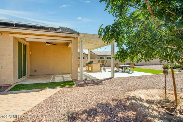 a view of a patio with a table and chairs under an umbrella