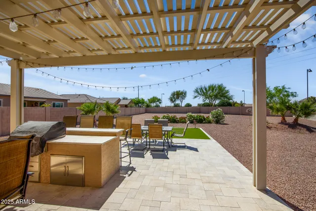 a view of a patio with table and chairs near a yard
