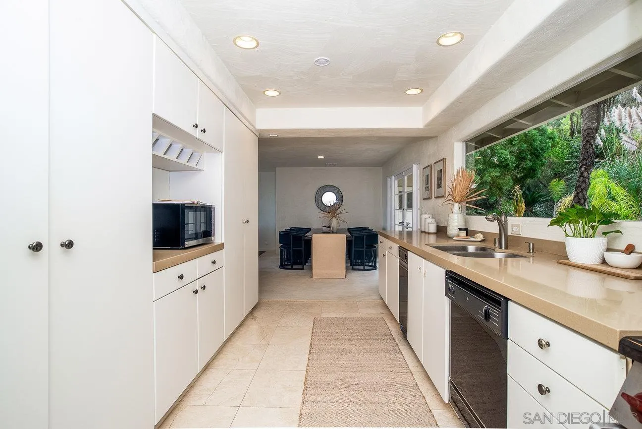 2349 Rue Adriane La Jolla, CA 92037 - Photo 13 of 36 a large white kitchen with a large window and stainless steel appliances