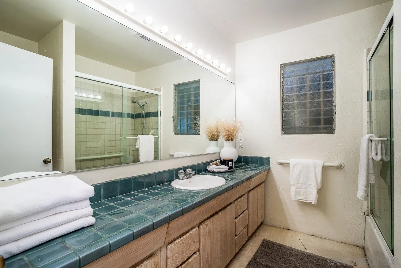 2349 Rue Adriane La Jolla, CA 92037 - Photo 27 of 36 a bathroom with a granite countertop sink and a mirror