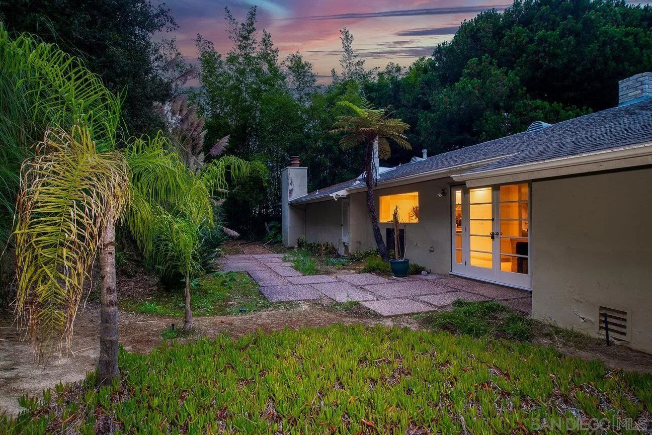 2349 Rue Adriane La Jolla, CA 92037 - Photo 28 of 36 a backyard of a house with table and chairs plants and large trees