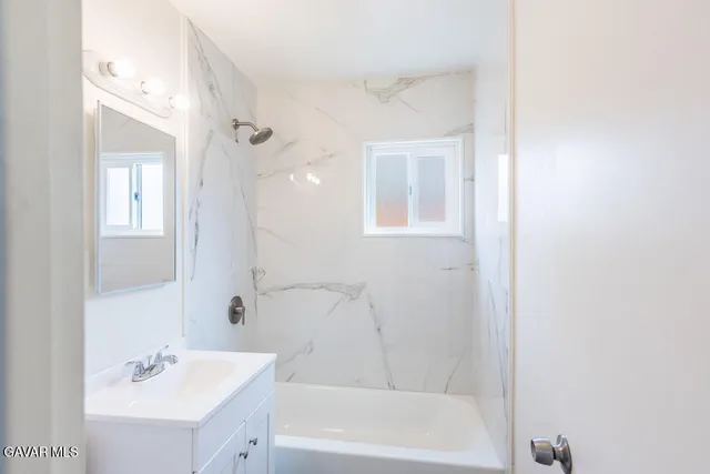 a bathroom with a bathtub a shower a sink and a mirror