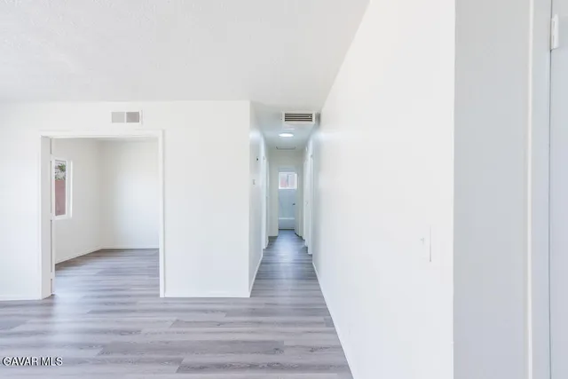 a view of a hallway with wooden floor
