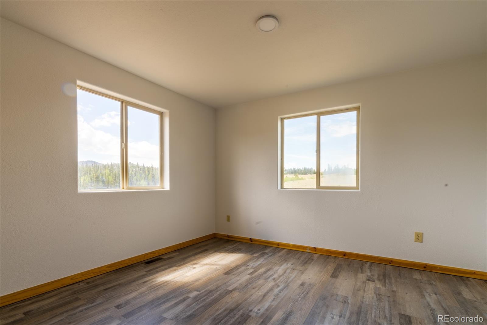 1155 Travois Road Jefferson, CO 80456 - Photo 14 of 31 an empty room with wooden floor and windows