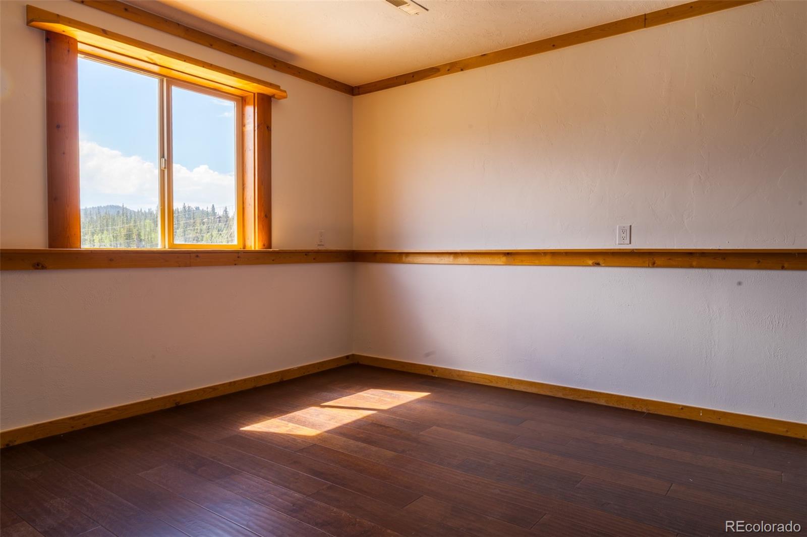 1155 Travois Road Jefferson, CO 80456 - Photo 24 of 31 a view of an empty room with wooden floor and a window