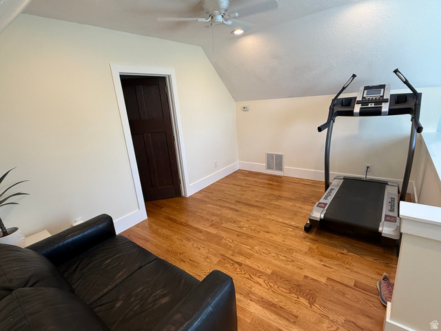 776 Canyon Road Hyde Park, UT 84318 - Photo 19 of 57 Attic space featuring wood-finish flooring, a ceiling fan with integrated lighting, and a dark wood panel door