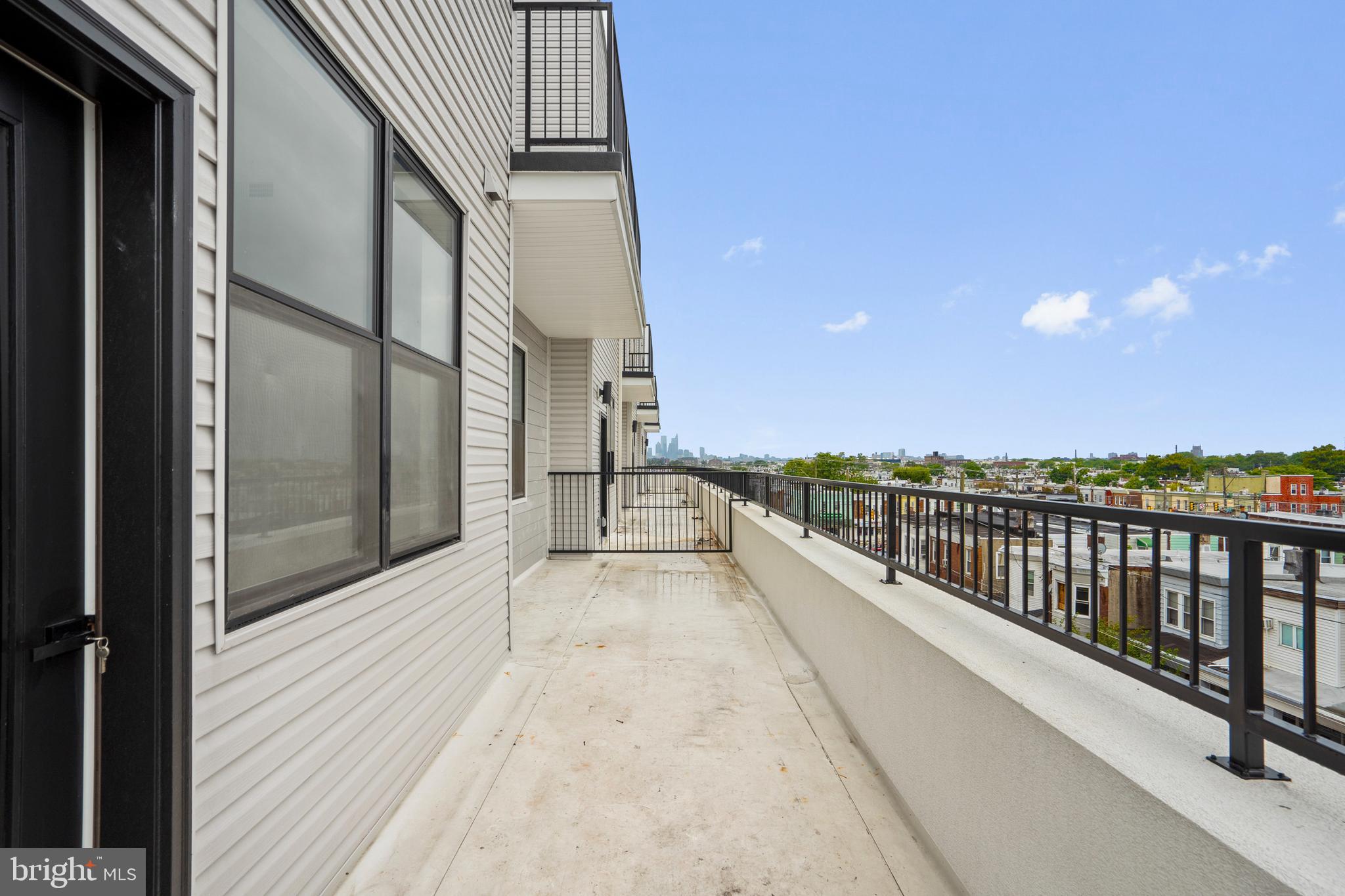 3211 Cedar Street, Unit 401 Philadelphia, PA 19134 - Photo 11 of 18 a view of a balcony with wooden floor and fence