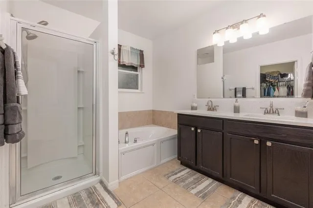 a spacious bathroom with a tub sink shower and mirror