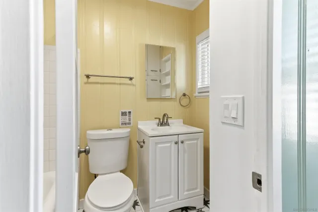 a bathroom with a toilet a sink and mirror