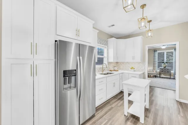 a kitchen with stainless steel appliances a refrigerator sink and cabinets