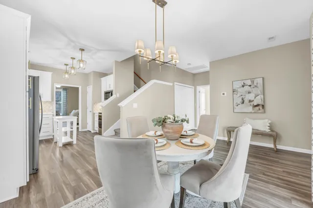 a view of a dining room with furniture wooden floor and chandelier