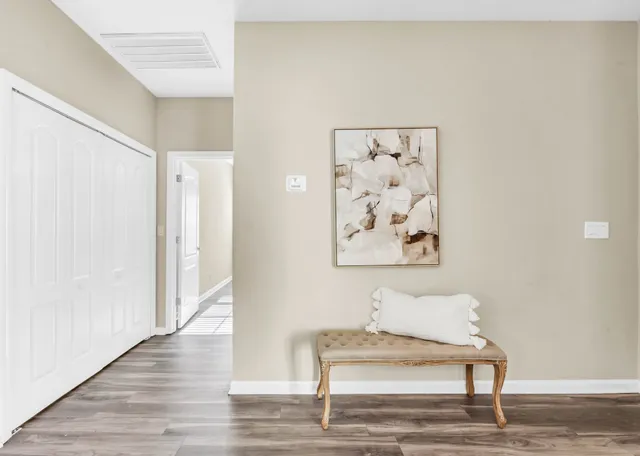 a view of a hallway with wooden floor and cabinet