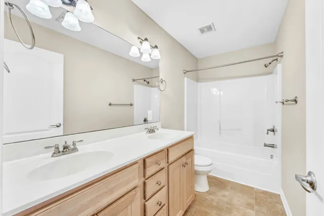 a bathroom with a granite countertop sink mirror toilet and bathtub
