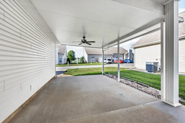 a view of a house with a yard and road