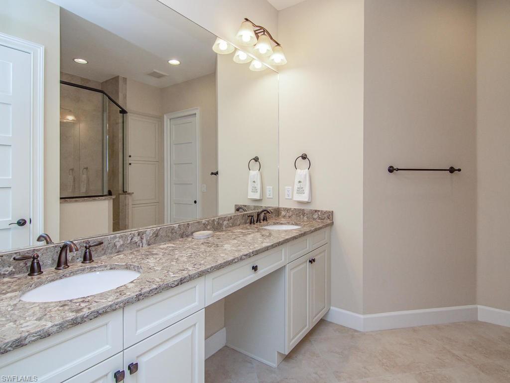 7002 Dominica Drive Naples, FL 34113 - Photo 24 of 33 a bathroom with a granite countertop double vanity sink and a mirror