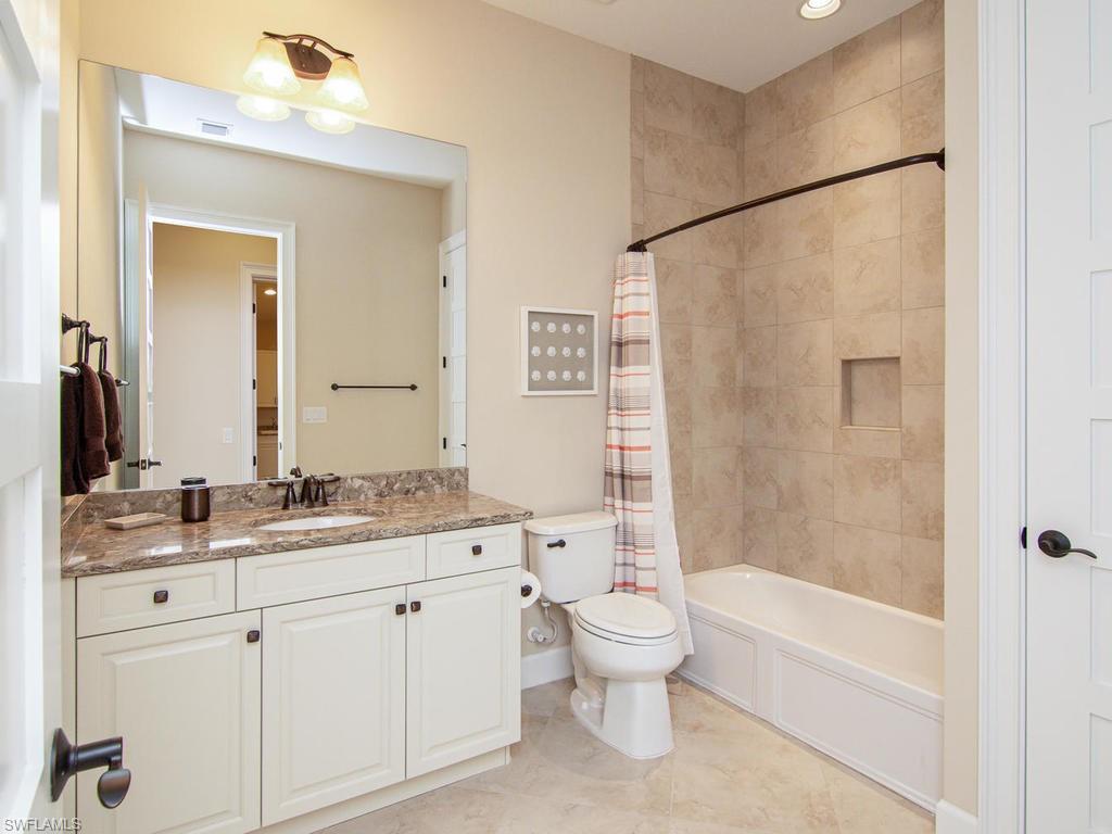 7002 Dominica Drive Naples, FL 34113 - Photo 26 of 33 a bathroom with a double vanity sink toilet and shower