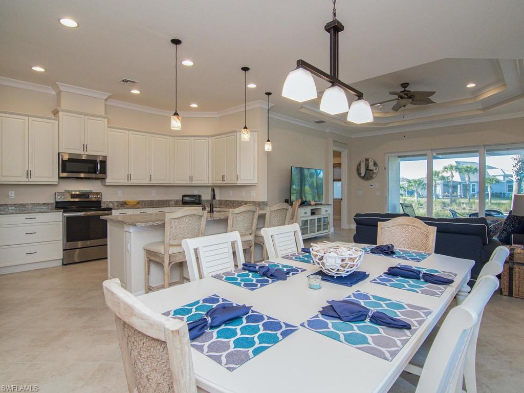 7002 Dominica Drive Naples, FL 34113 - Photo 4 of 33 a view of a dining room and livingroom with furniture wooden floor kitchen view and a chandelier