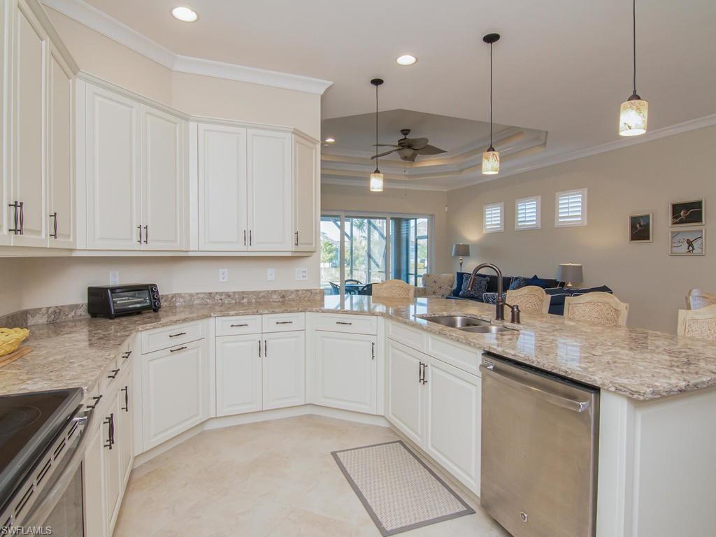 7002 Dominica Drive Naples, FL 34113 - Photo 10 of 33 a kitchen with a sink window and cabinets