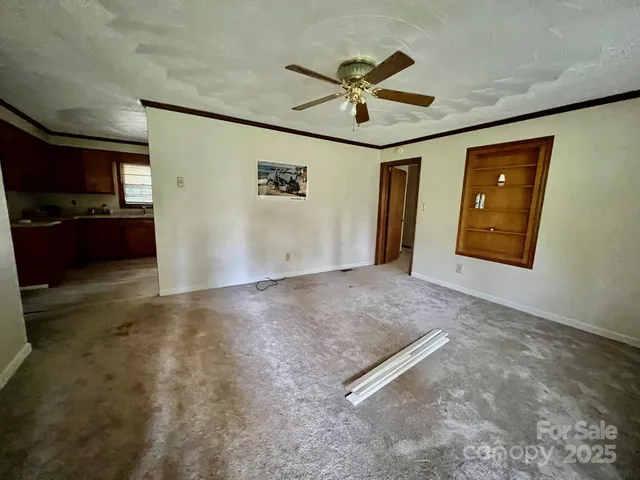 an empty room with windows and ceiling fan