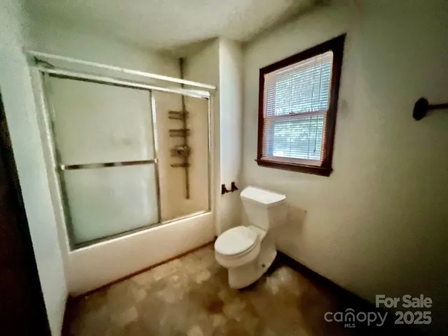 a bathroom with a toilet and a shower