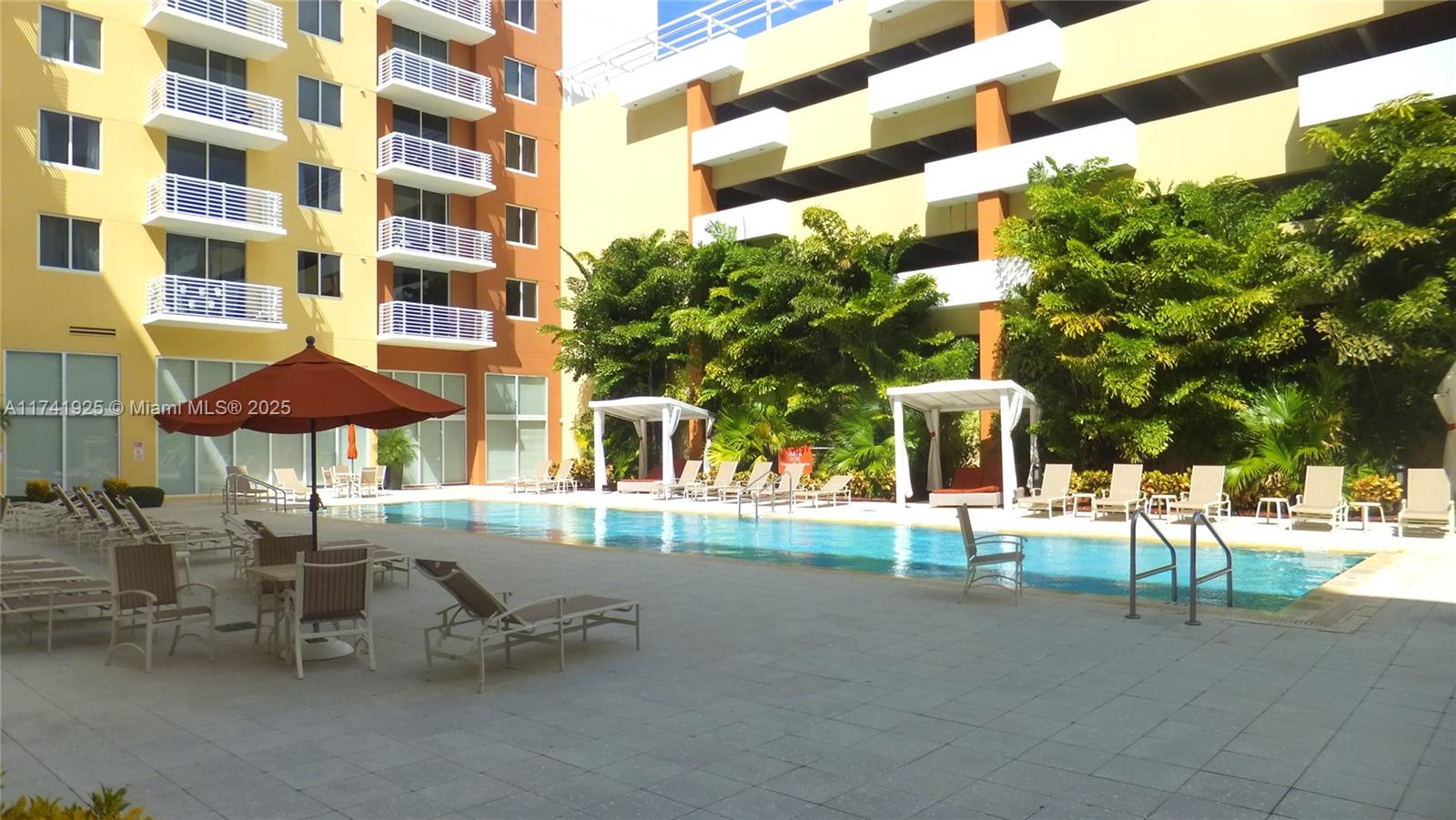 2775 Northeast 187th Street, Unit 329 Aventura, FL 33180 - Photo 18 of 21 a view of a patio with a table and chairs under an umbrella
