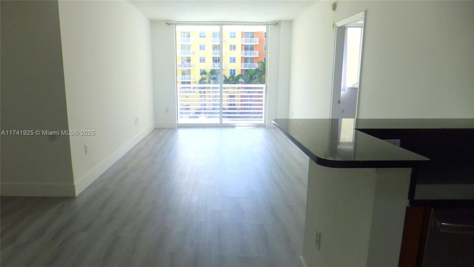 2775 Northeast 187th Street, Unit 329 Aventura, FL 33180 - Photo 2 of 21 an empty room with wooden floor and windows