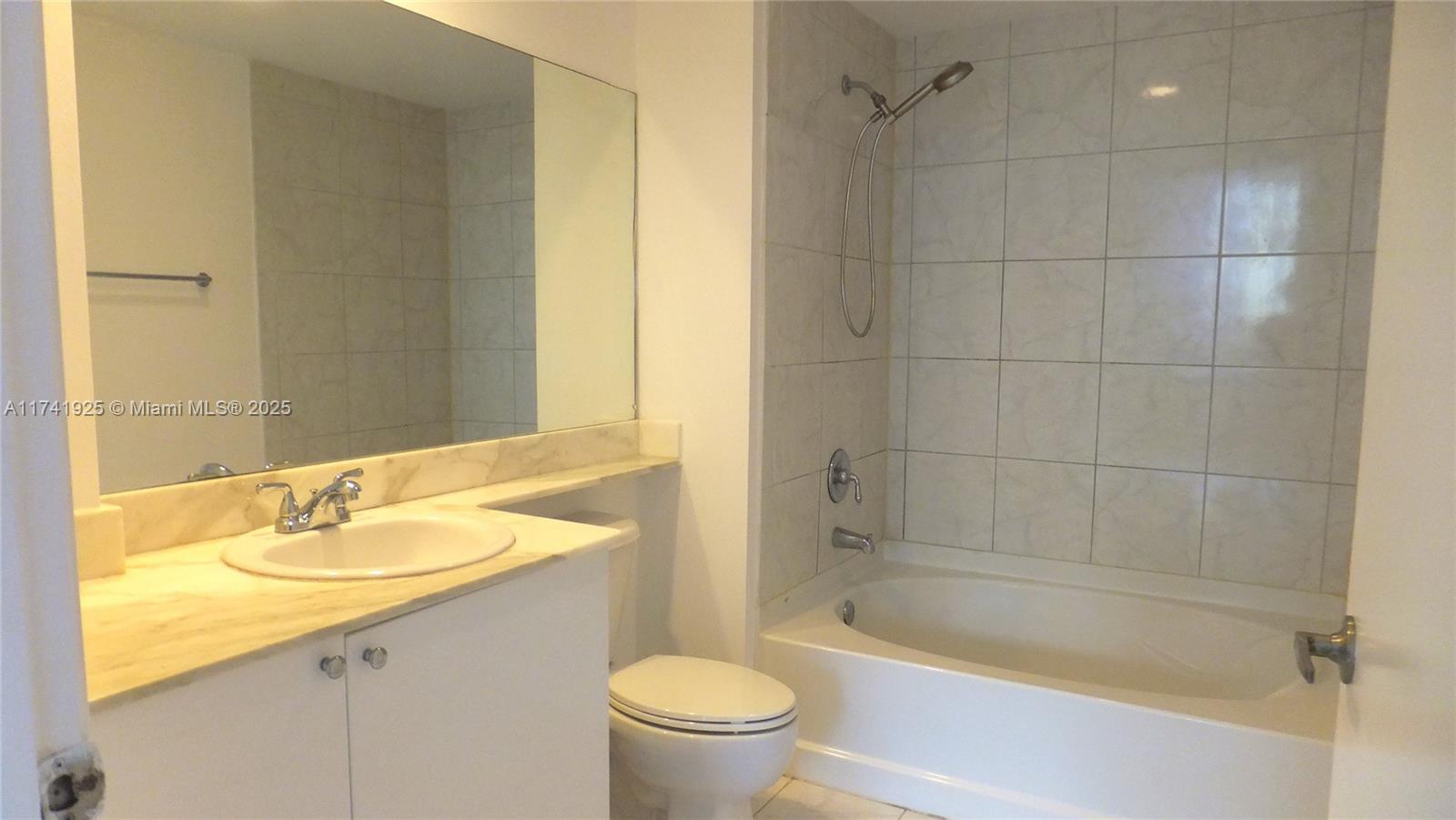 2775 Northeast 187th Street, Unit 329 Aventura, FL 33180 - Photo 6 of 21 a bathroom with a granite countertop sink a toilet and bathtub