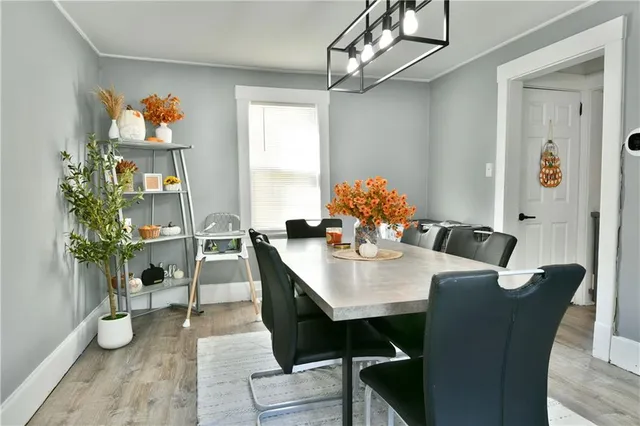 a dining room with furniture potted plants and wooden floor