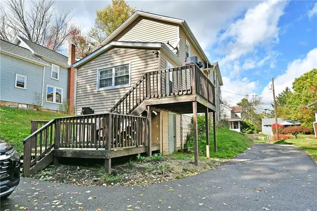 a view of a brick house with a small yard and plants