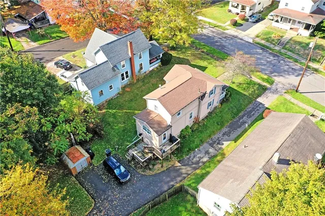 an aerial view of a house with a yard and ocean