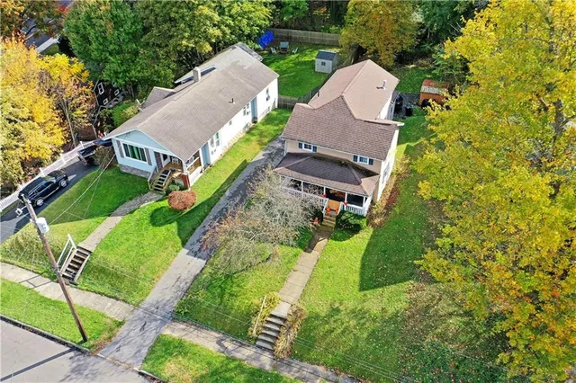 an aerial view of a house with a yard and lake view