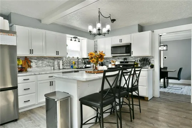 a kitchen with a dining table chairs a sink and cabinets