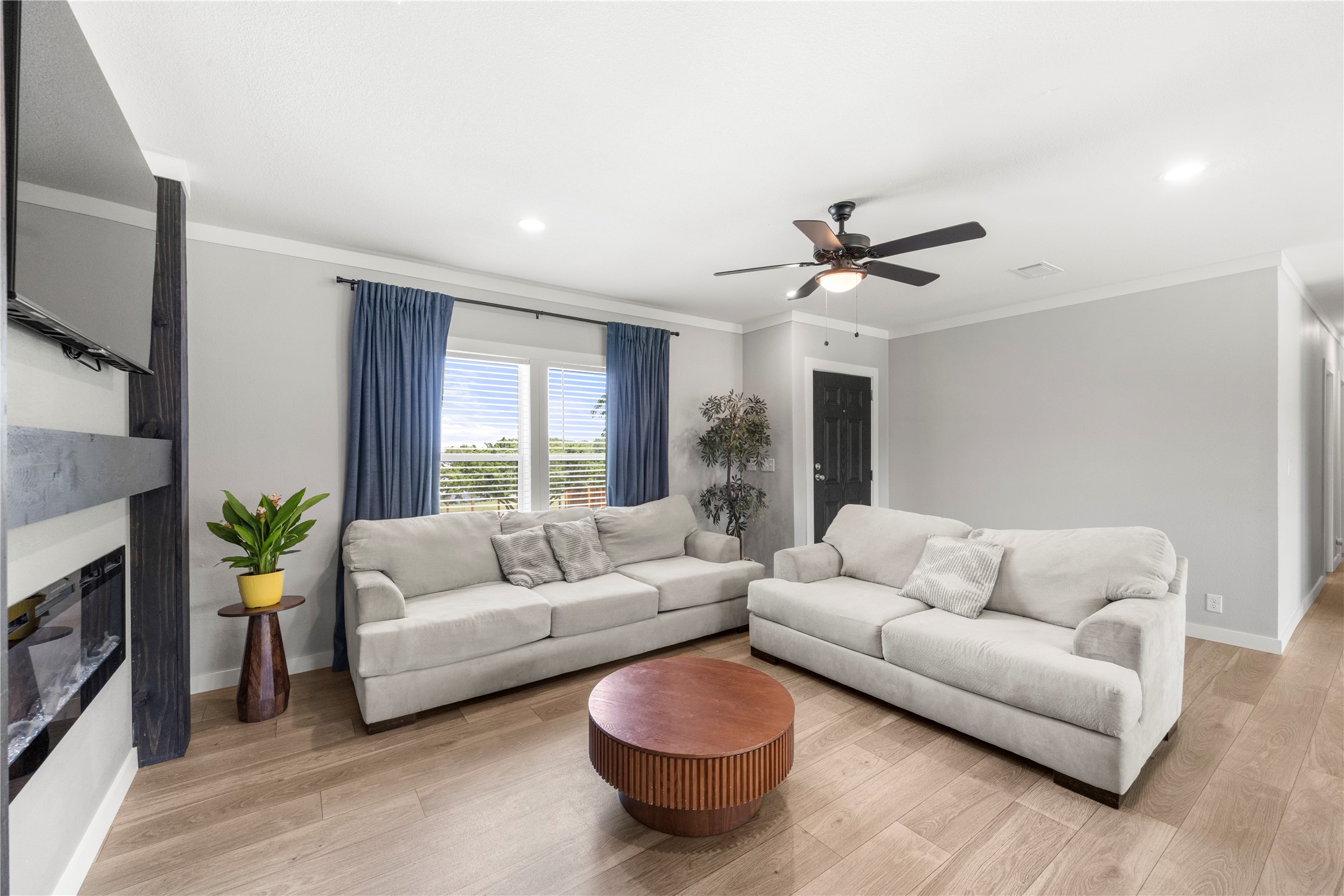 201 Greenfield Road Kyle, TX 78640 - Photo 22 of 28 A welcoming living area showcases light hardwood flooring, crown molding, and a warm, inviting ambiance.