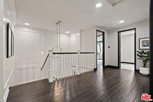 a view of a hallway with wooden floor and stairs