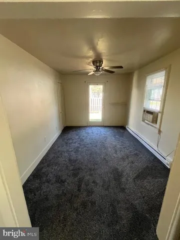 en empty room with windows and ceiling fan