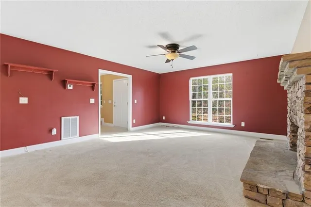 a view of an empty room with a fireplace and a window